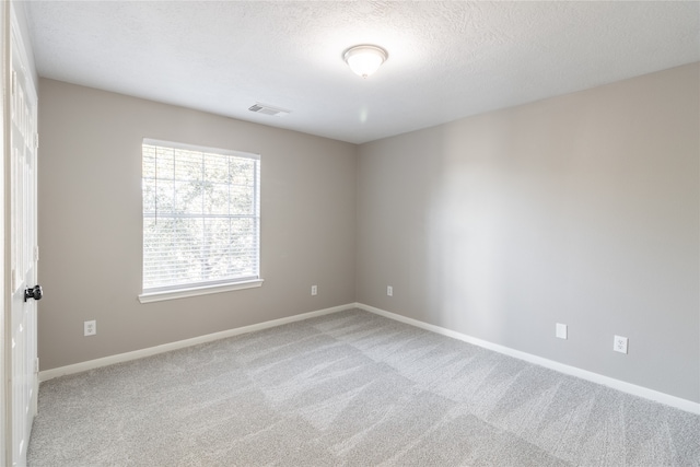 empty room featuring carpet and a textured ceiling