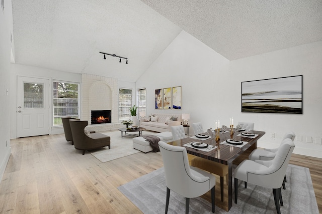 dining room with a fireplace, hardwood / wood-style floors, and a textured ceiling