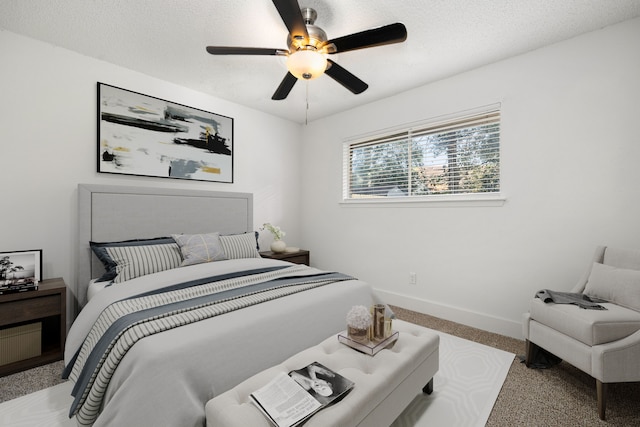 carpeted bedroom featuring a textured ceiling and ceiling fan