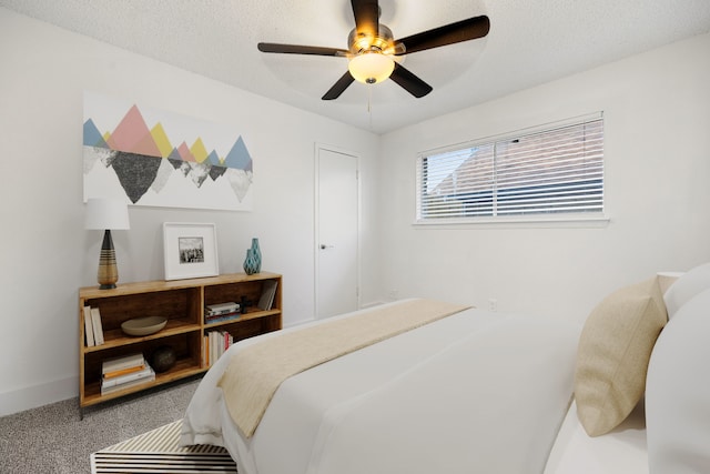 bedroom with ceiling fan, a textured ceiling, and carpet flooring