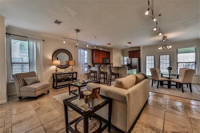 living room featuring crown molding and a notable chandelier