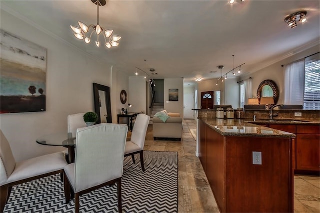 dining area featuring sink, a notable chandelier, and crown molding