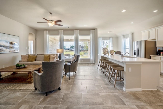 living room with ceiling fan and sink