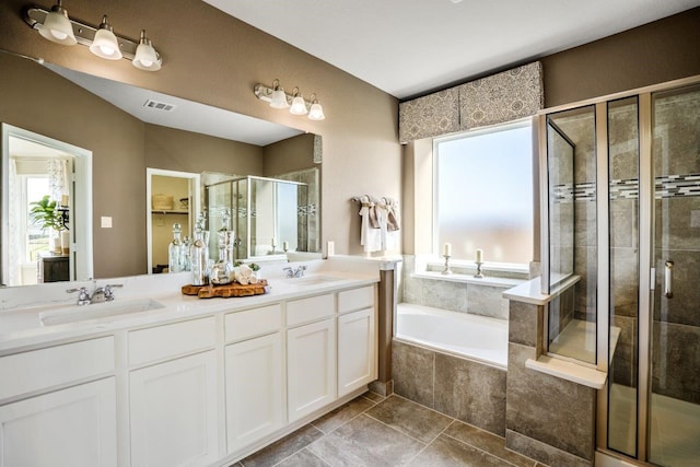 bathroom with vanity, independent shower and bath, and a wealth of natural light