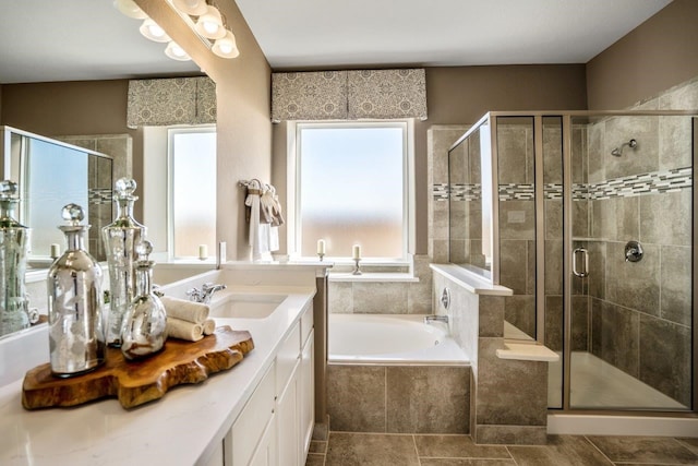 bathroom featuring tile patterned flooring, vanity, and shower with separate bathtub