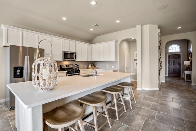 kitchen featuring sink, stainless steel appliances, an island with sink, and white cabinets