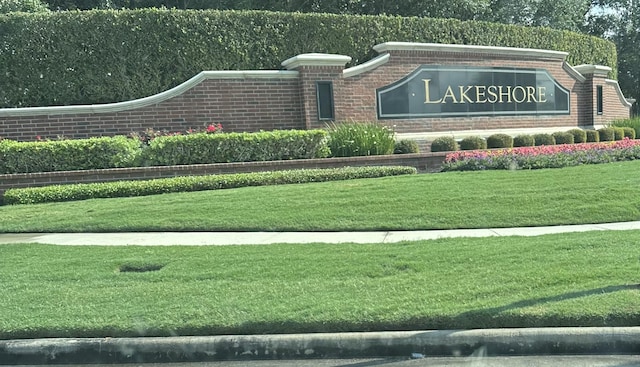 community sign featuring a lawn