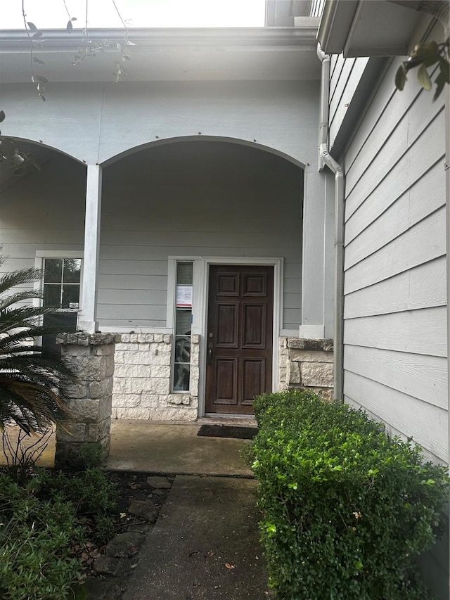 view of exterior entry featuring a porch