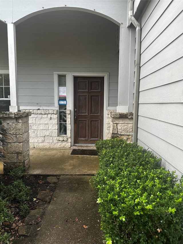 view of exterior entry with a porch