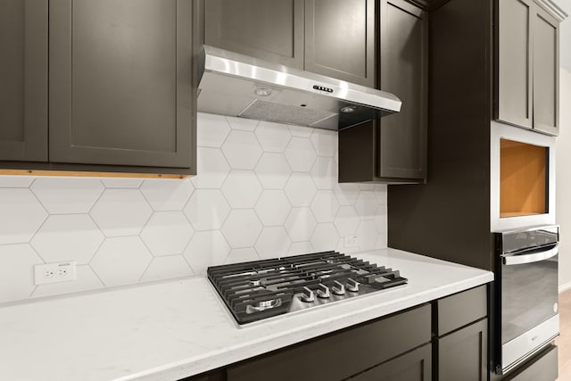 kitchen with gray cabinets, stainless steel appliances, and tasteful backsplash