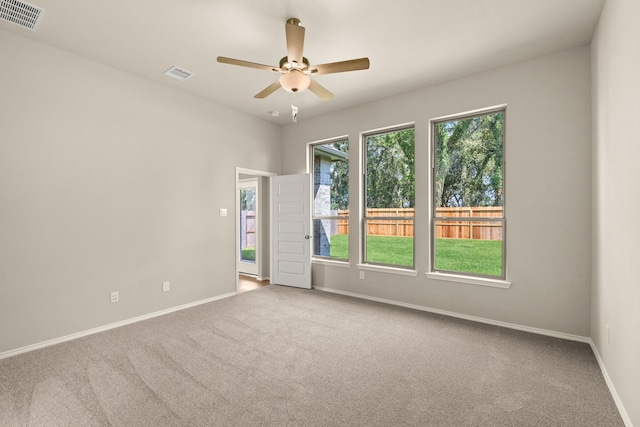 carpeted spare room with ceiling fan and a healthy amount of sunlight