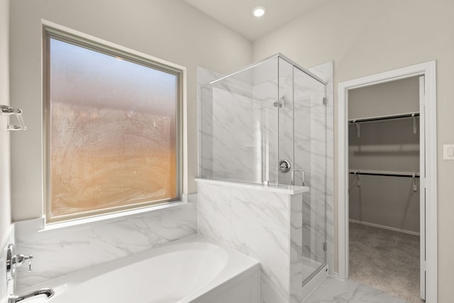 bathroom featuring shower with separate bathtub