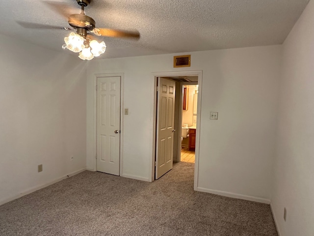 unfurnished bedroom with ceiling fan, a textured ceiling, and light colored carpet