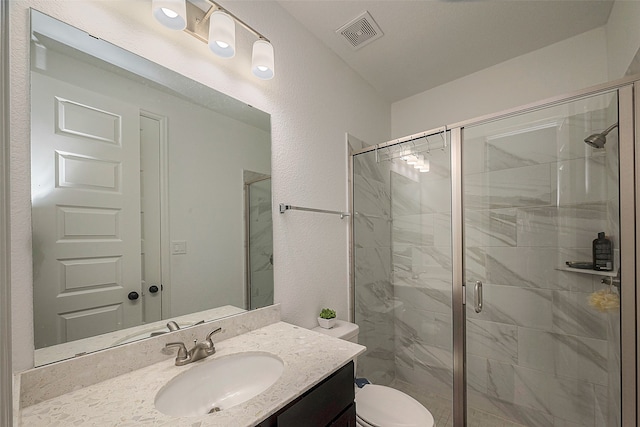 bathroom with an enclosed shower, vanity, and toilet