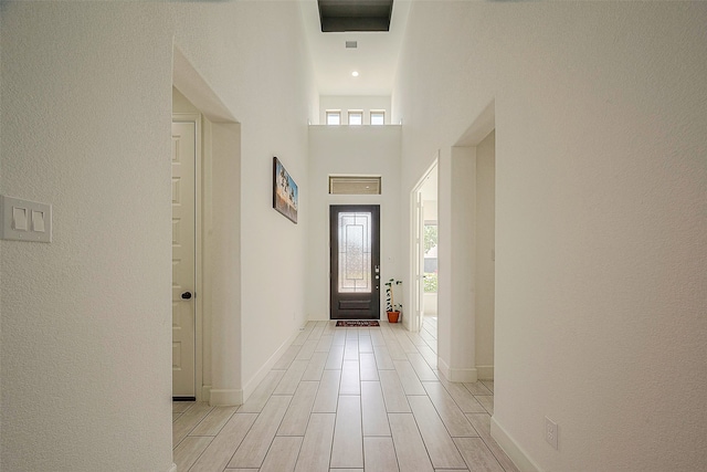 entrance foyer with light wood-type flooring and a towering ceiling