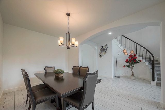 dining area featuring light wood-type flooring and a notable chandelier