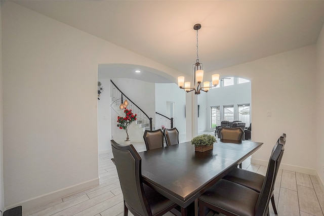 dining area with light wood-type flooring and an inviting chandelier