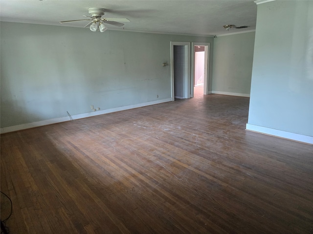 empty room with ceiling fan, dark hardwood / wood-style flooring, and crown molding