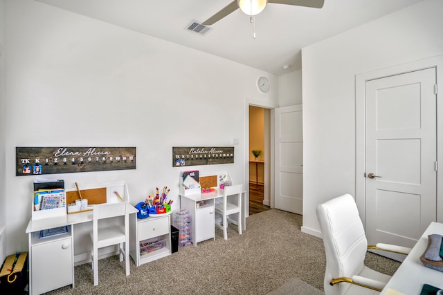 carpeted office space with ceiling fan