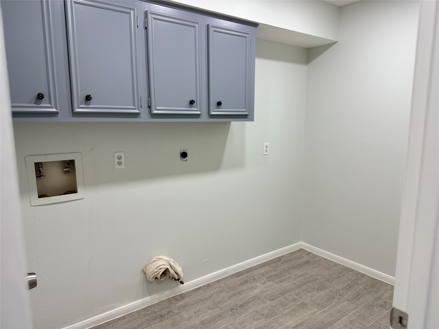 washroom featuring hookup for an electric dryer, light wood-type flooring, hookup for a washing machine, and cabinets