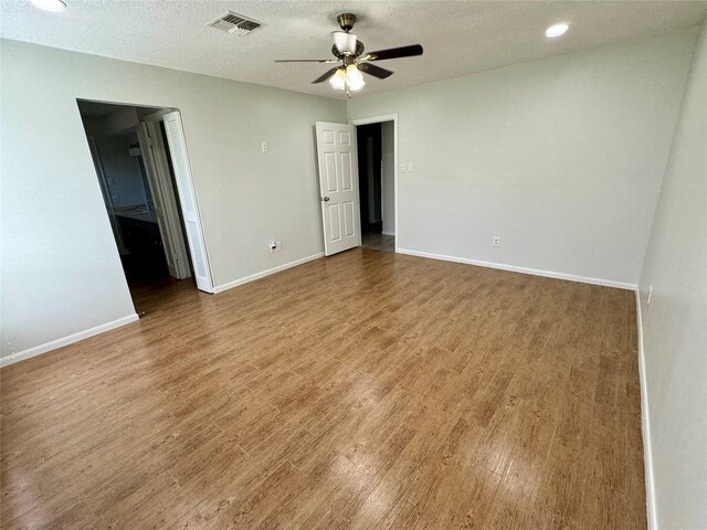 unfurnished room with a textured ceiling, wood-type flooring, and ceiling fan