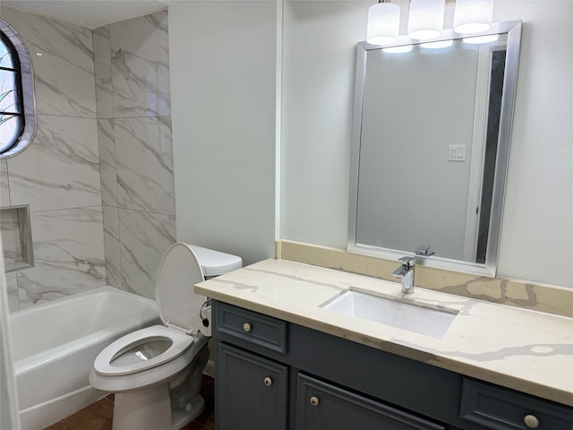 full bathroom featuring toilet, vanity, and tiled shower / bath