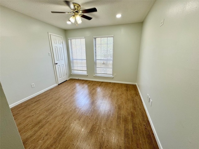 unfurnished room with ceiling fan, wood-type flooring, and a textured ceiling