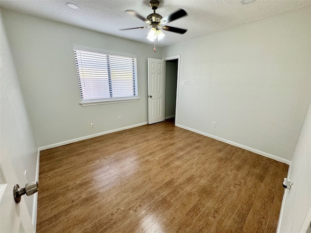 spare room featuring a textured ceiling, hardwood / wood-style flooring, and ceiling fan