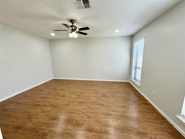 unfurnished room featuring a textured ceiling, hardwood / wood-style flooring, and ceiling fan