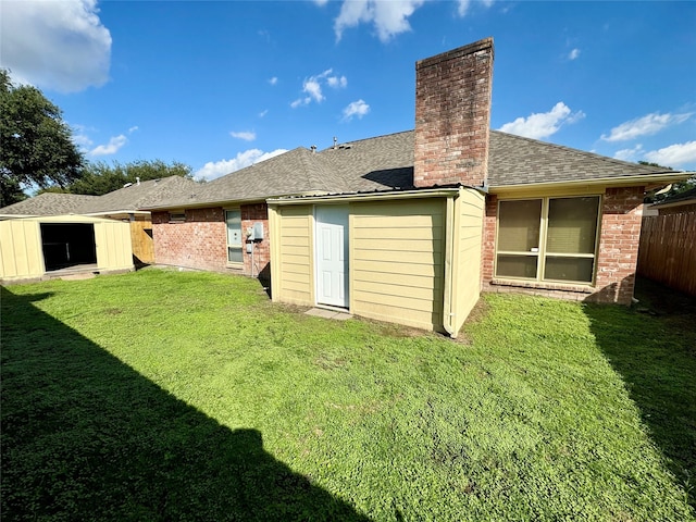 back of house with a yard and a storage shed