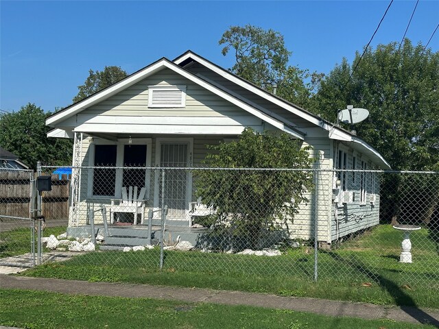 bungalow-style home featuring a front lawn and covered porch