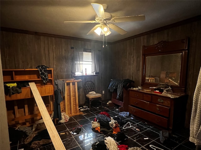 bedroom featuring dark tile patterned floors, wood walls, ceiling fan, and crown molding