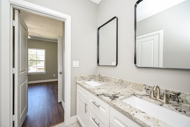 bathroom featuring hardwood / wood-style flooring, vanity, and crown molding