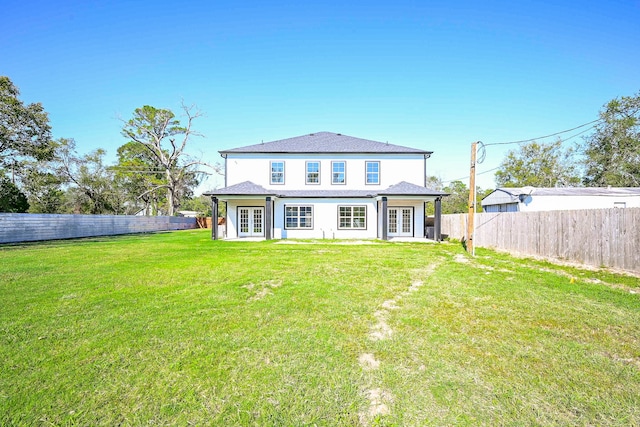 rear view of house featuring a yard and french doors