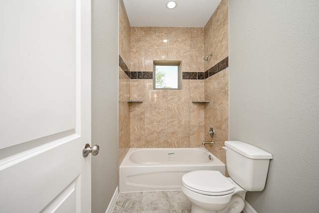 bathroom featuring toilet and tiled shower / bath combo