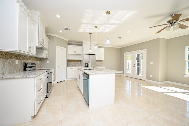 kitchen with white cabinets, appliances with stainless steel finishes, decorative light fixtures, and a kitchen island with sink