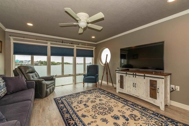 living room with ceiling fan, a textured ceiling, crown molding, and wood-type flooring