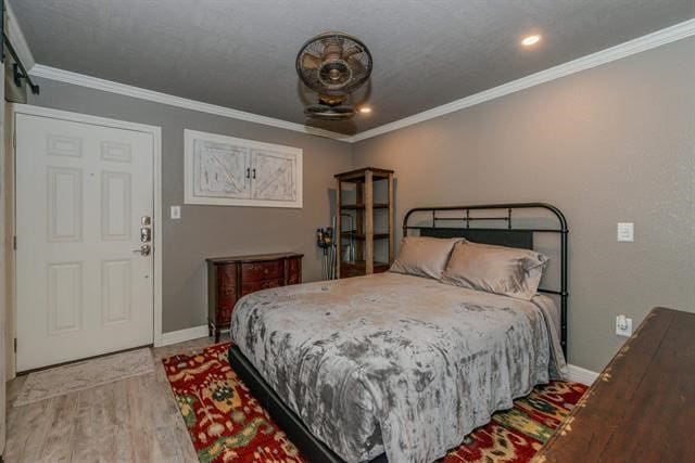 bedroom with light wood-type flooring and crown molding