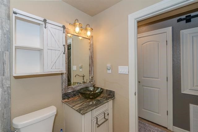 bathroom with toilet and vanity