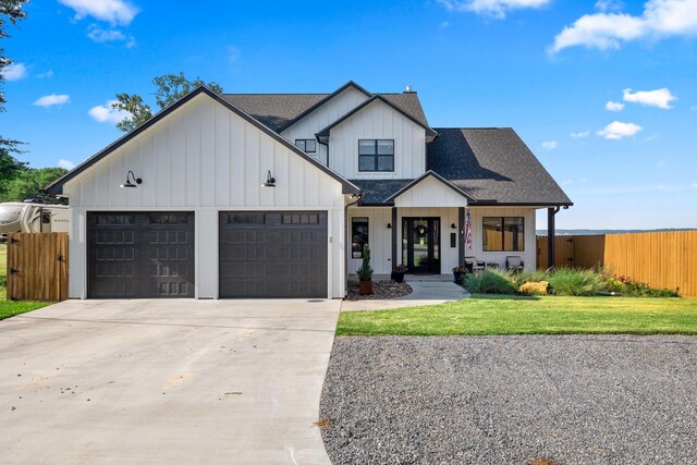 modern farmhouse style home featuring a porch, a garage, and a front lawn