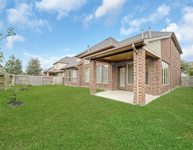 rear view of house with a patio area and a lawn