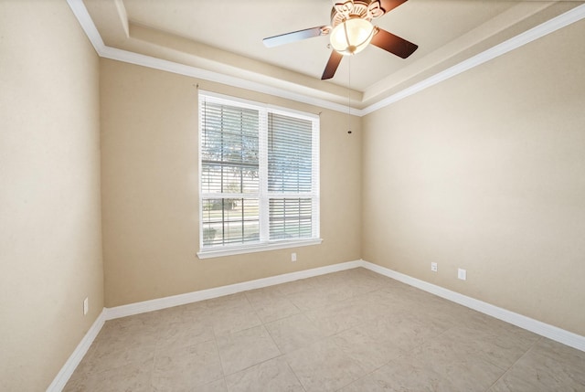 empty room featuring a raised ceiling, ceiling fan, and ornamental molding