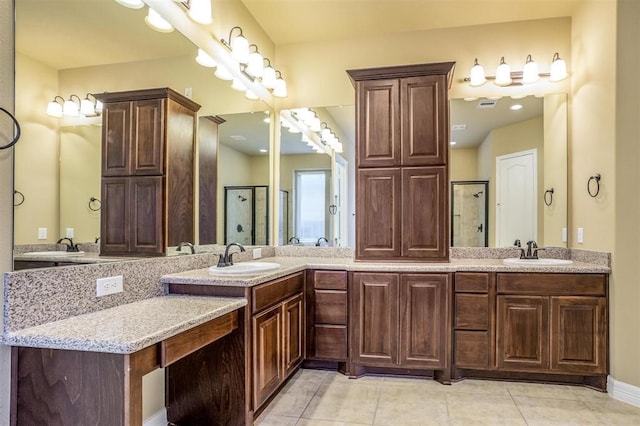 bathroom with tile patterned flooring, vanity, and a shower with door