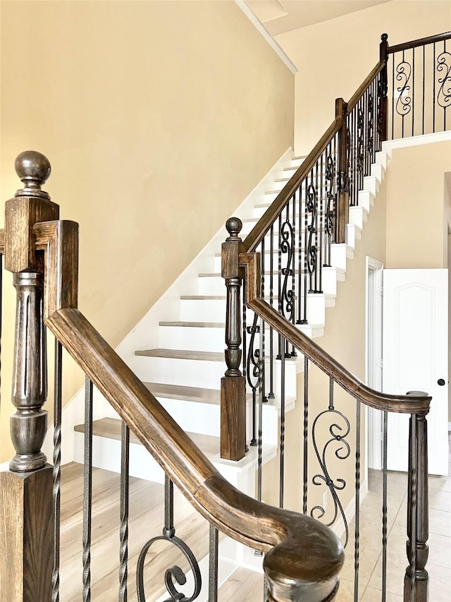 stairway featuring hardwood / wood-style floors and a high ceiling