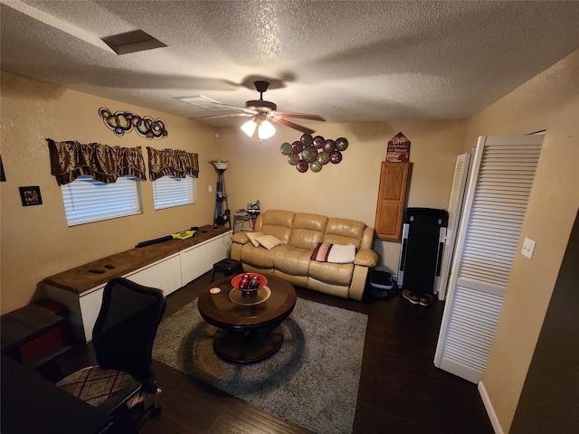 living room with dark hardwood / wood-style flooring, a textured ceiling, and ceiling fan