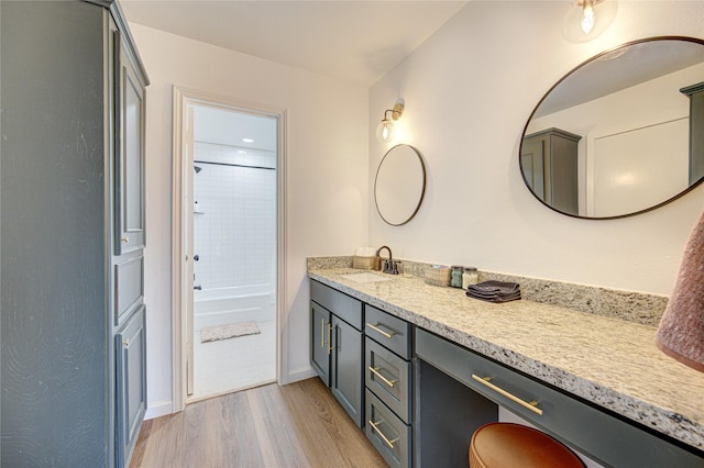 9932 Shady Dr, Houston, TX 77016 - full bath with vanity, wood finished floors, bathing tub / shower combination, and baseboards