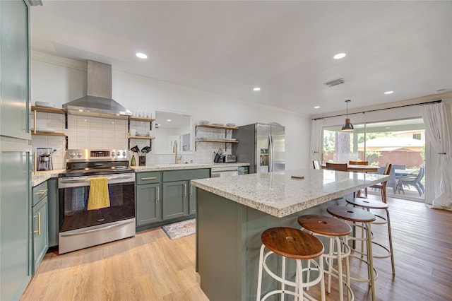 9932 Shady Dr, Houston, TX 77016 - kitchen featuring stainless steel appliances, open shelves, wall chimney exhaust hood, decorative backsplash, and light wood-style floors
