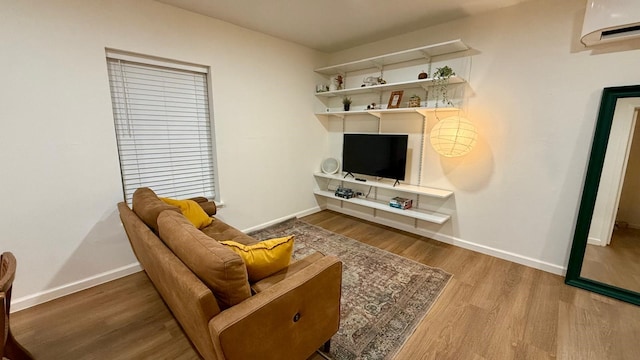 9932 Shady Dr, Houston, TX 77016 - living area featuring baseboards, wood finished floors, and an AC wall unit