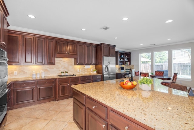 kitchen featuring appliances with stainless steel finishes, tasteful backsplash, light stone counters, crown molding, and sink