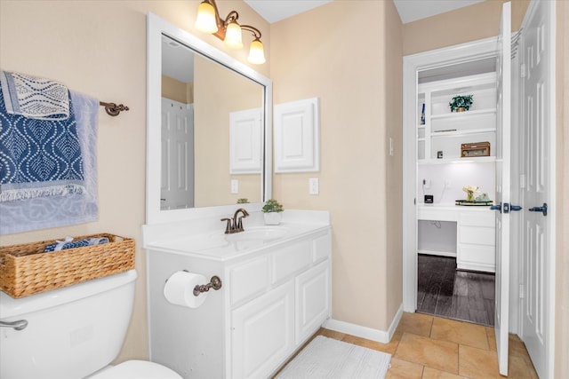 bathroom with tile patterned flooring, vanity, and toilet